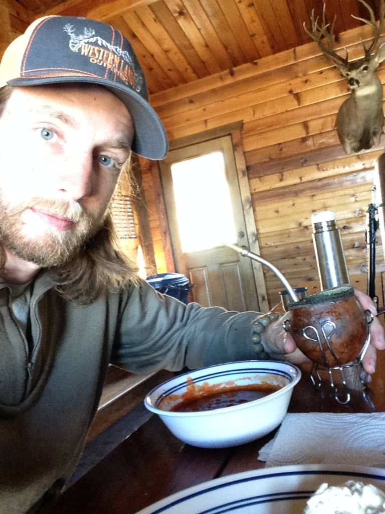 Drinking mate and eating chili in the cabin after a morning of hunting
