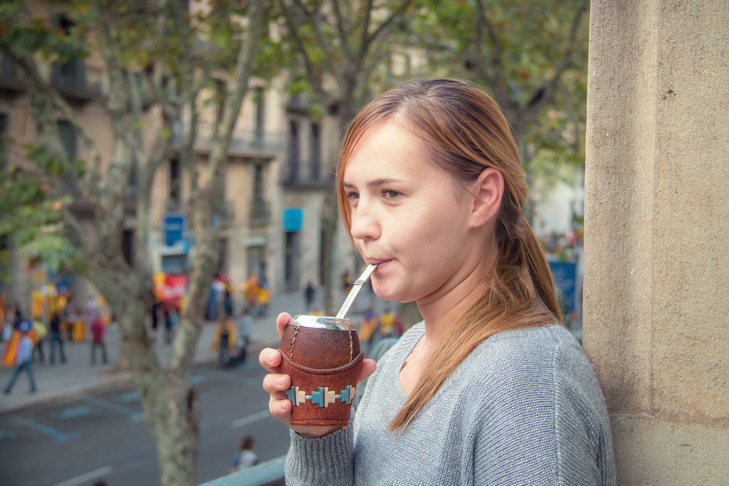 A young woman unknowingly slurping all the evil that Yerba Mate contains